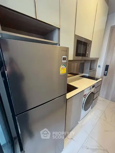 Modern kitchen with sleek appliances and stylish cabinetry in a contemporary apartment.