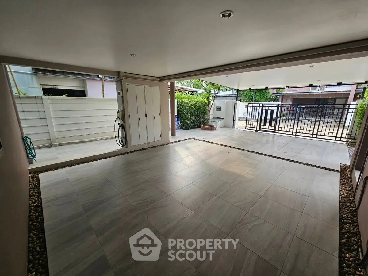 Spacious covered parking area with modern design and secure gate access.