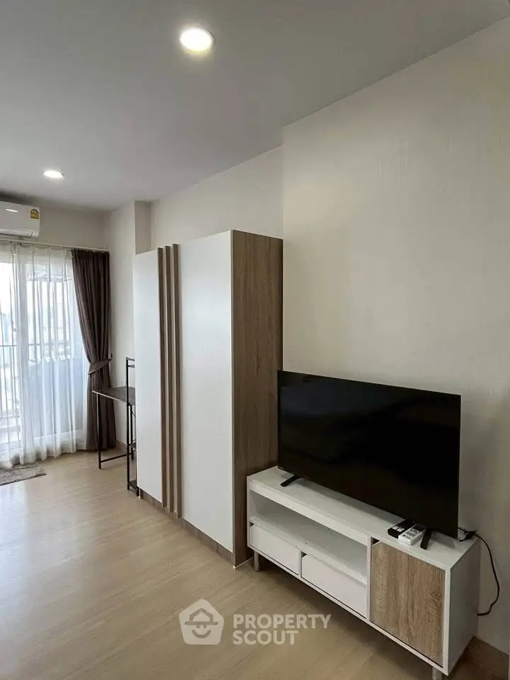 Modern living room with sleek TV stand and large window for natural light.