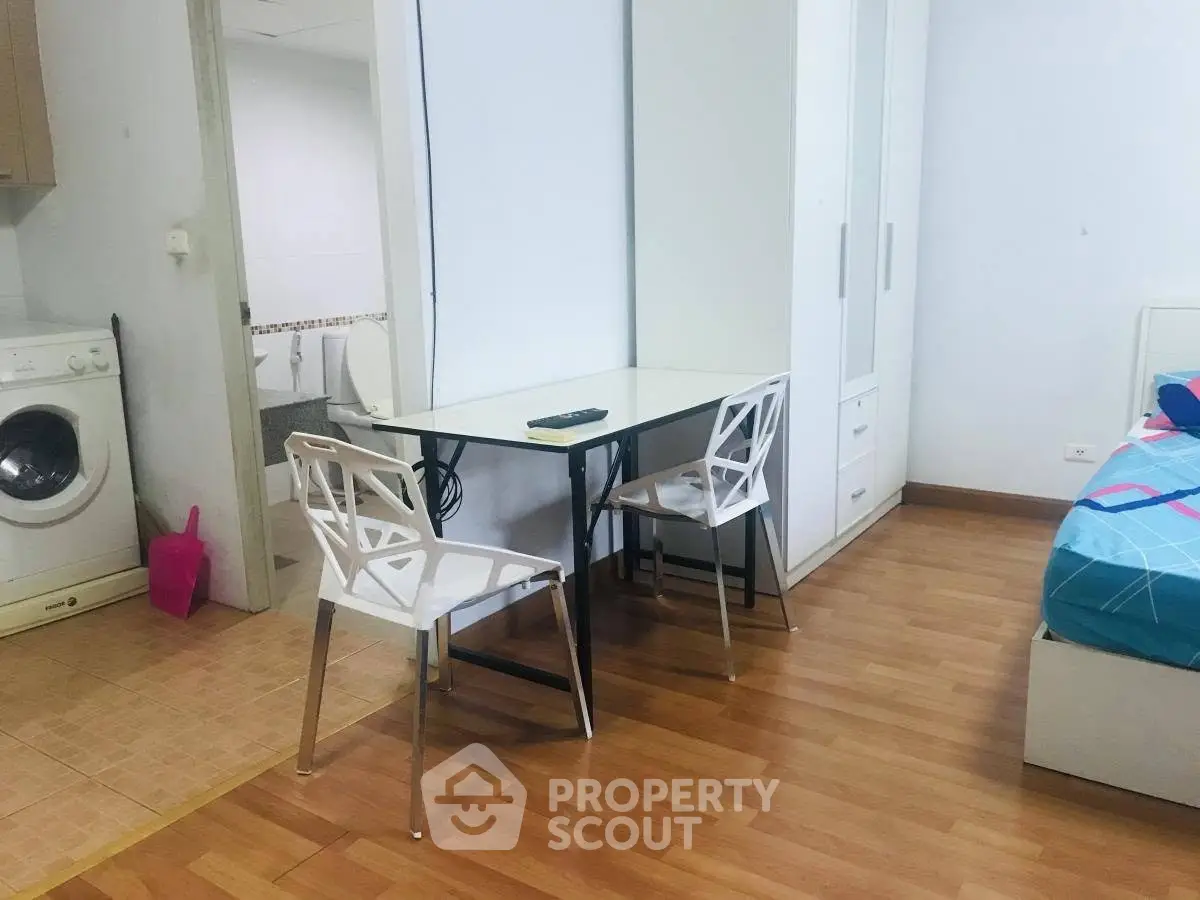 Cozy apartment interior with dining area and washing machine, perfect for modern living.