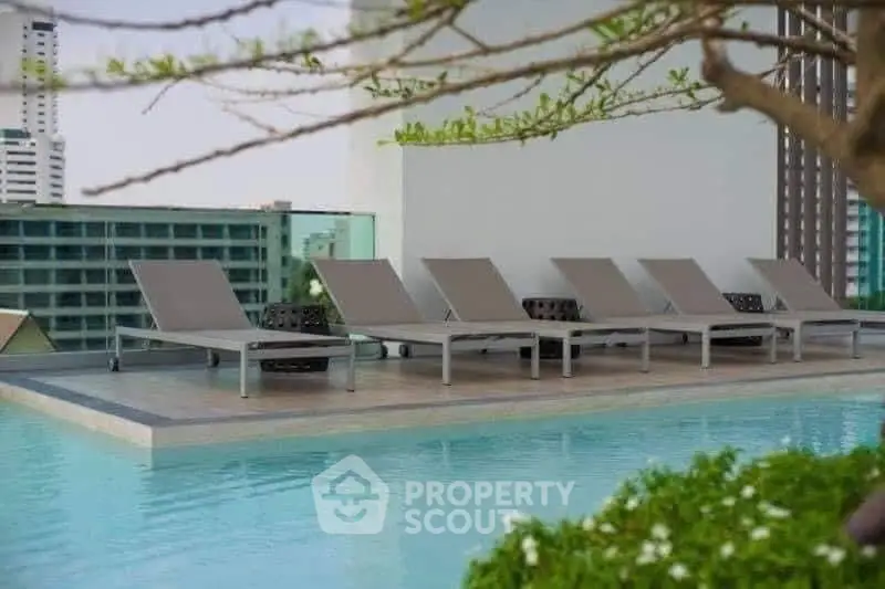 Luxurious rooftop pool with modern sun loungers and stunning city views, perfect for relaxation and leisure.