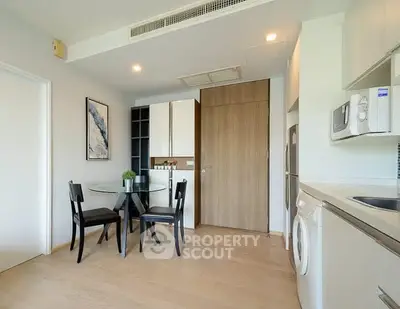 Modern kitchen with dining area, featuring sleek appliances and minimalist design.