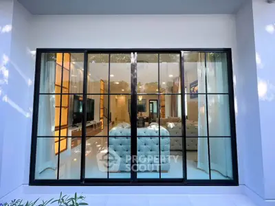 Luxurious living room with large glass windows and elegant interior design.