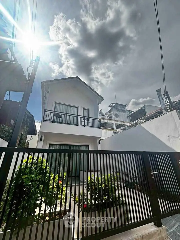 Charming two-story house with modern design and gated entrance, perfect for family living.