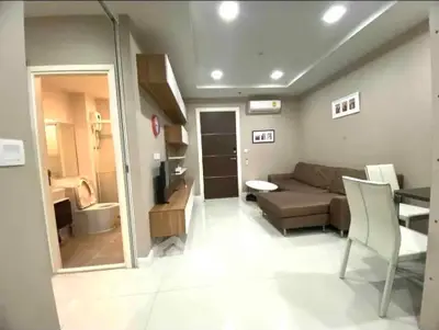 Modern living room with sleek furniture and open layout, adjacent to a stylish bathroom.