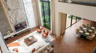 Luxurious open-plan living room with high ceilings and elegant dining area, featuring modern decor and large windows.