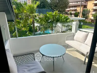 Charming balcony with cozy seating and lush garden view, perfect for relaxation.