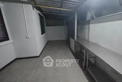 Spacious industrial-style kitchen with stainless steel countertops and ample storage space.