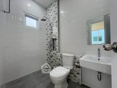 Modern bathroom with sleek tiles and contemporary fixtures in a stylish home.