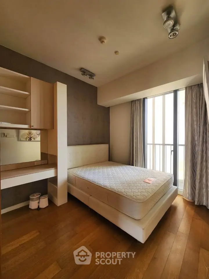 Spacious bedroom with natural light and modern furnishings in a stylish apartment.
