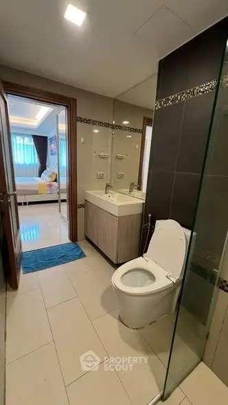 Modern bathroom with sleek design and view into a cozy bedroom