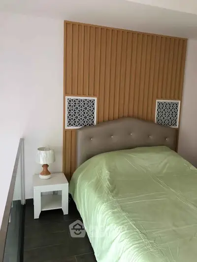 Modern bedroom with stylish headboard and cozy bedding in a contemporary apartment.