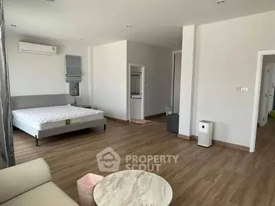 Spacious bedroom with modern furnishings and wooden flooring