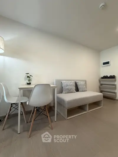Modern minimalist living room with cozy seating and dining area, perfect for urban living.