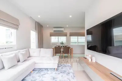 Spacious modern living room with large TV and elegant dining area