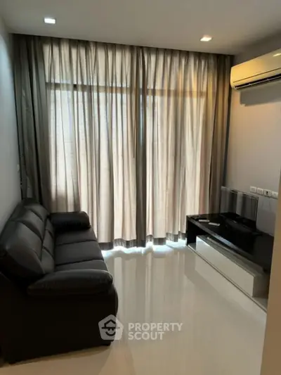 Modern living room with sleek black sofa and air conditioning