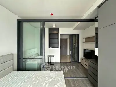 Modern studio apartment with sliding glass doors and sleek furnishings