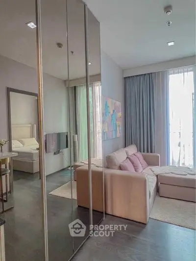 Modern living room with cozy sofa and mirrored wardrobe in stylish apartment.