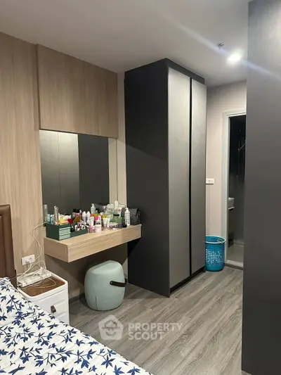 Modern bedroom with stylish wardrobe and vanity area, featuring sleek design and ample storage space.