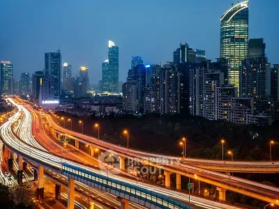 Stunning city skyline with illuminated skyscrapers and busy highway at dusk, showcasing urban living.