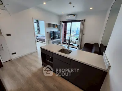 Modern open-plan living room with kitchen island and city view balcony