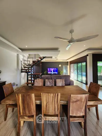 Spacious modern living room with wooden dining set and stylish staircase