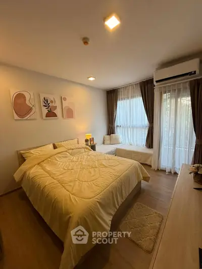 Cozy bedroom with modern decor and natural light, featuring a comfortable bed and stylish artwork.