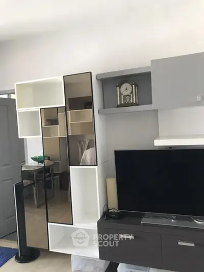 Modern living room with sleek shelving and flat-screen TV, perfect for contemporary urban living.