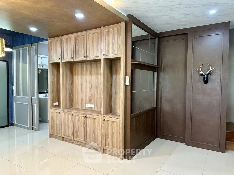 Spacious living area with elegant wooden cabinetry and modern lighting