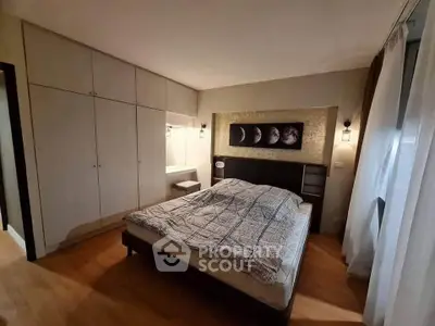Spacious bedroom with modern decor and ample storage in a stylish apartment.