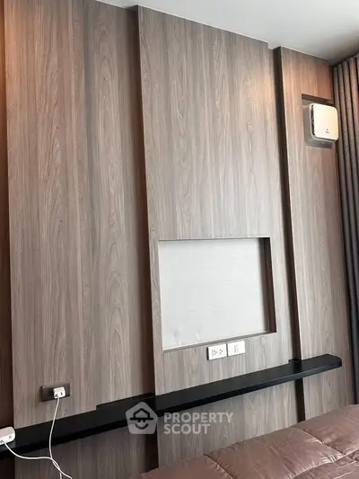 Modern bedroom with sleek wooden paneling and built-in shelf, perfect for contemporary living.