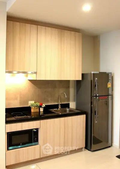 Modern kitchen with sleek cabinetry and stainless steel appliances in a stylish apartment.