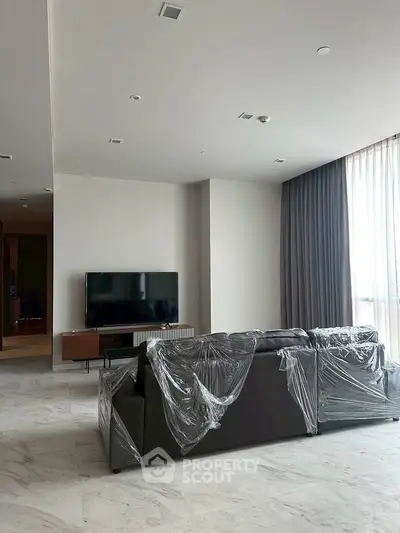 Spacious modern living room with sleek furniture and large windows for natural light.