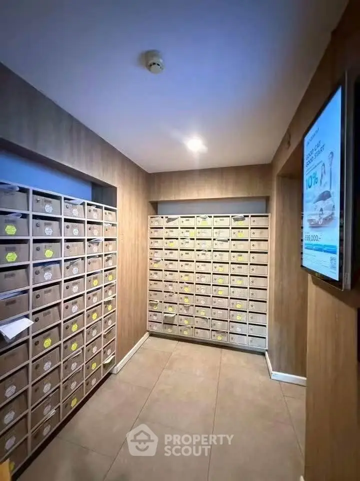 Modern apartment building mailroom with organized mailboxes and wooden paneling.