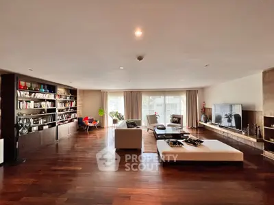 Spacious modern living room with elegant wooden flooring and large bookshelf