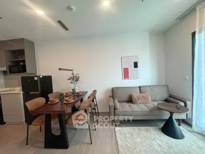Modern living room with dining area, stylish furniture, and natural light.