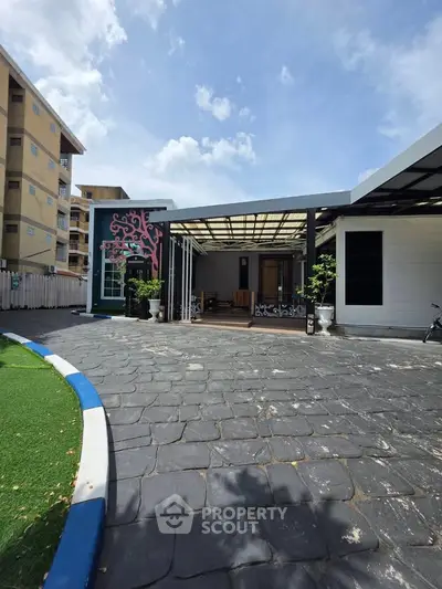 Modern house exterior with spacious driveway and artistic wall design