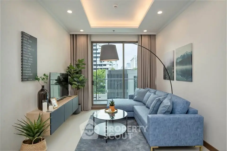 Modern living room with stylish blue sofa, large window, and elegant decor in a high-rise apartment.