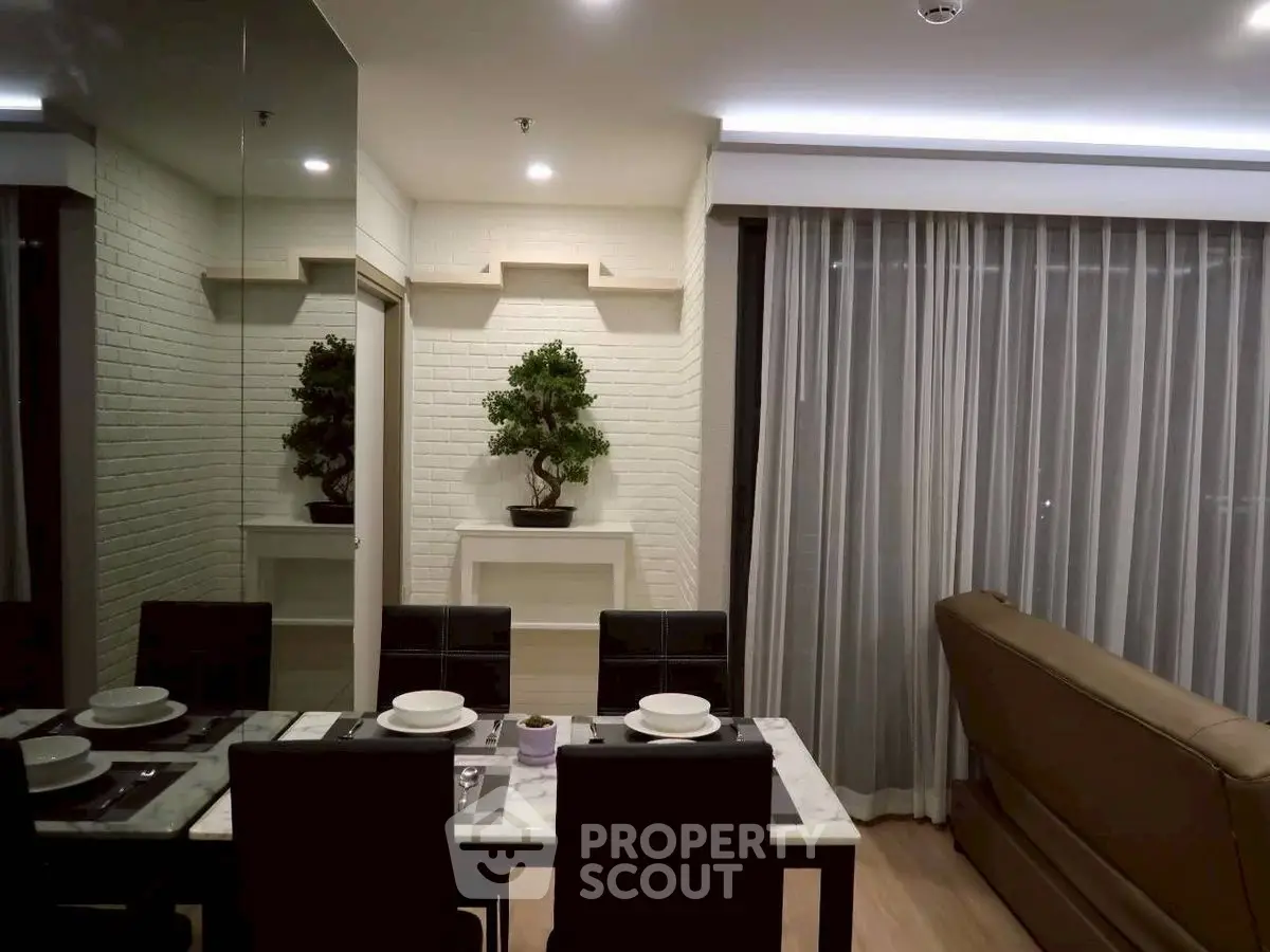 Modern living room with elegant dining area and cozy seating, featuring stylish decor and ambient lighting.