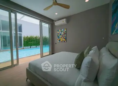 Luxurious bedroom with pool view and modern decor in a stylish home.