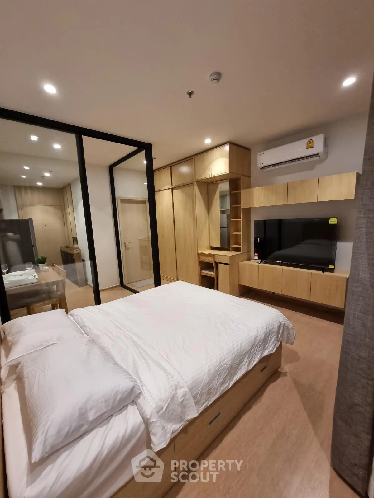 Modern bedroom with wooden furniture and sleek design, featuring a cozy bed and built-in storage.