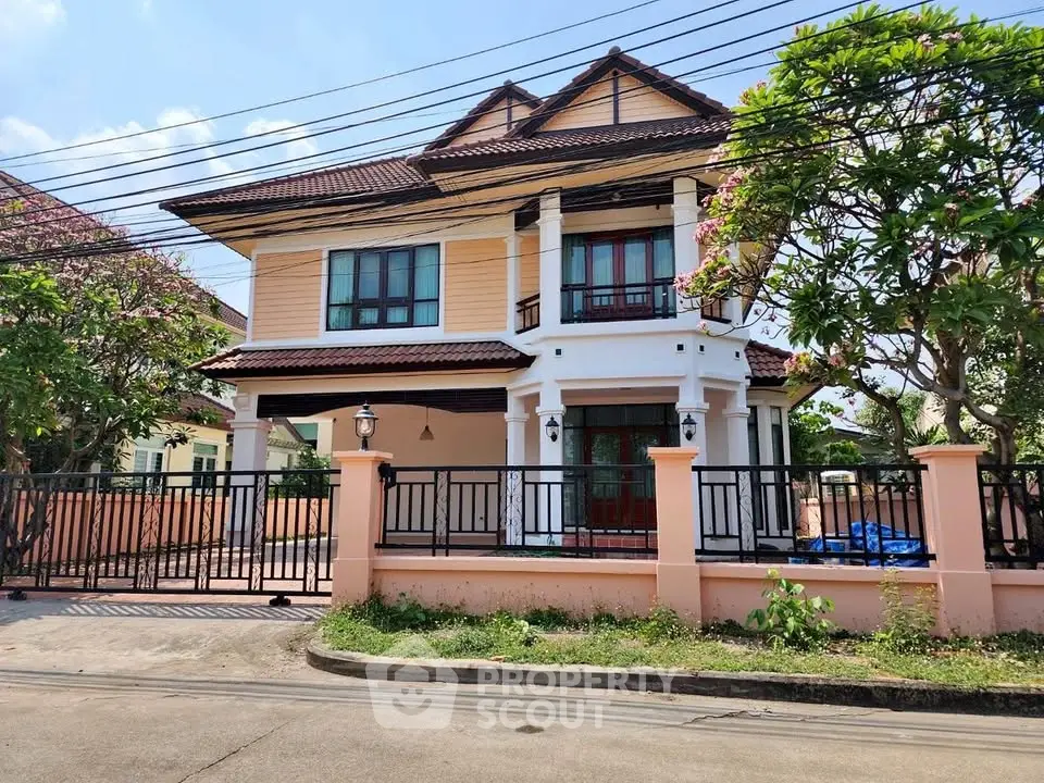 Charming two-story house with a spacious front yard and elegant balcony, perfect for family living.