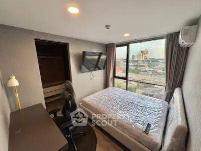 Modern bedroom with city view, featuring a sleek desk and comfortable bed, ideal for urban living.