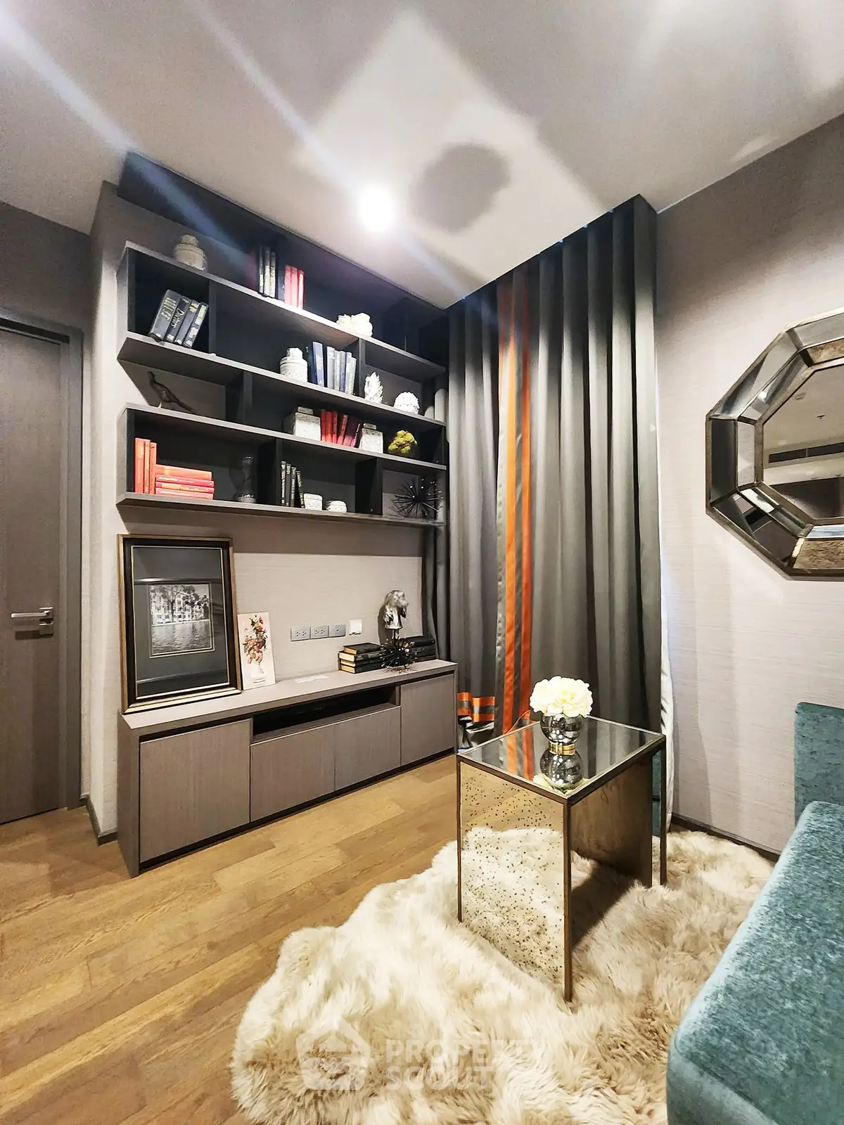 Luxurious living room with elegant decor, plush rug, and modern shelving for a sophisticated ambiance.