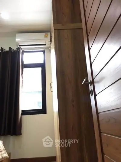 Cozy bedroom with wooden accents and air conditioning, perfect for comfort and relaxation.