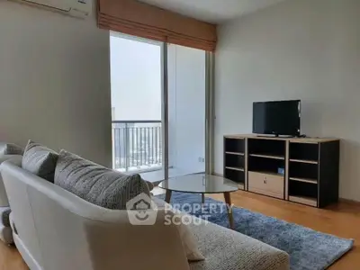 Modern living room with cozy sofa, glass coffee table, and balcony view in a stylish apartment.