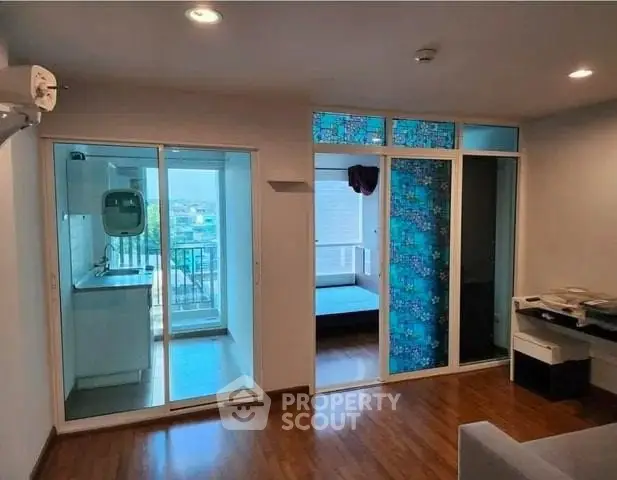 Modern apartment interior with sliding glass doors and wooden flooring