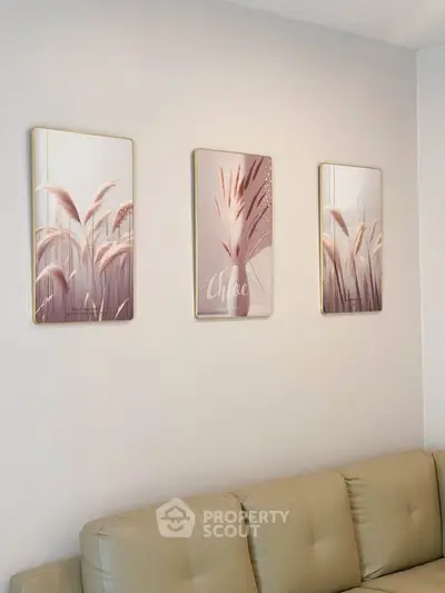 Modern living room with elegant wall art and beige leather sofa, perfect for stylish urban living.