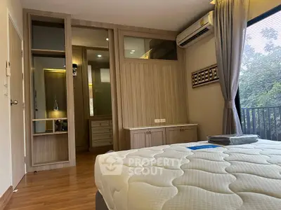 Modern bedroom with wooden flooring, built-in wardrobe, and large window with a view.