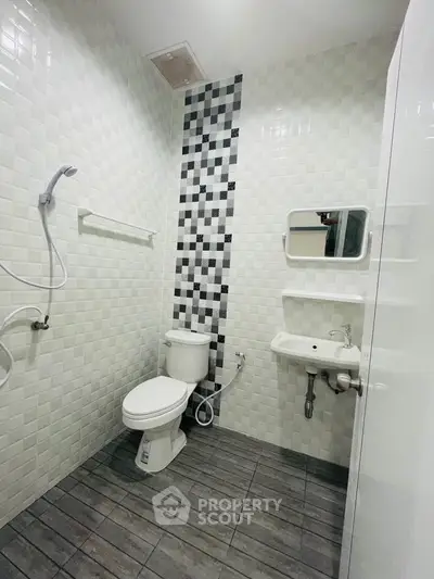 Modern bathroom with sleek tiles and compact fixtures, ideal for urban living.